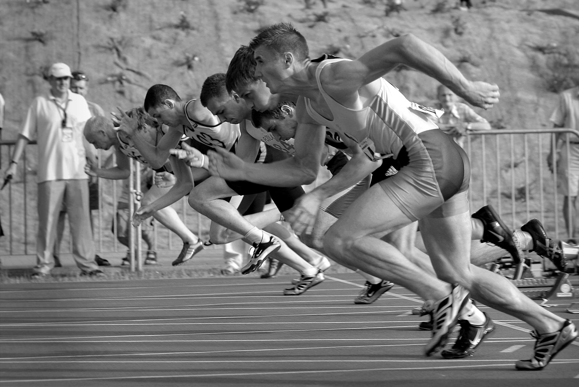 Sprinters launching from the starting line, representing fast-loading Shopify stores and the impact of a speed optimization checklist.