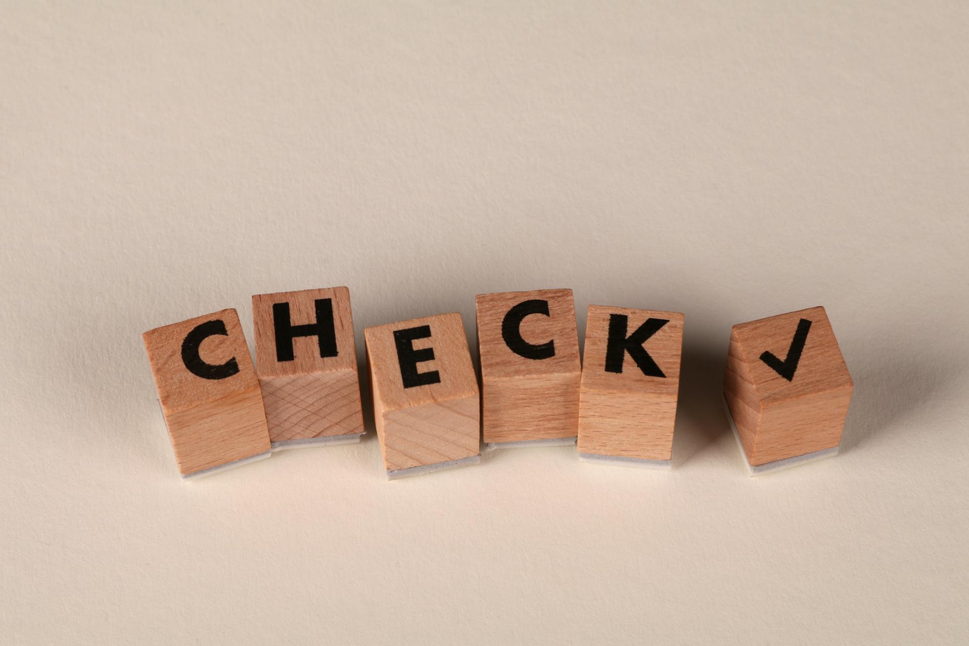Wooden blocks spelling “CHECK” with a checkmark, representing a completed speed optimization checklist for Shopify stores.