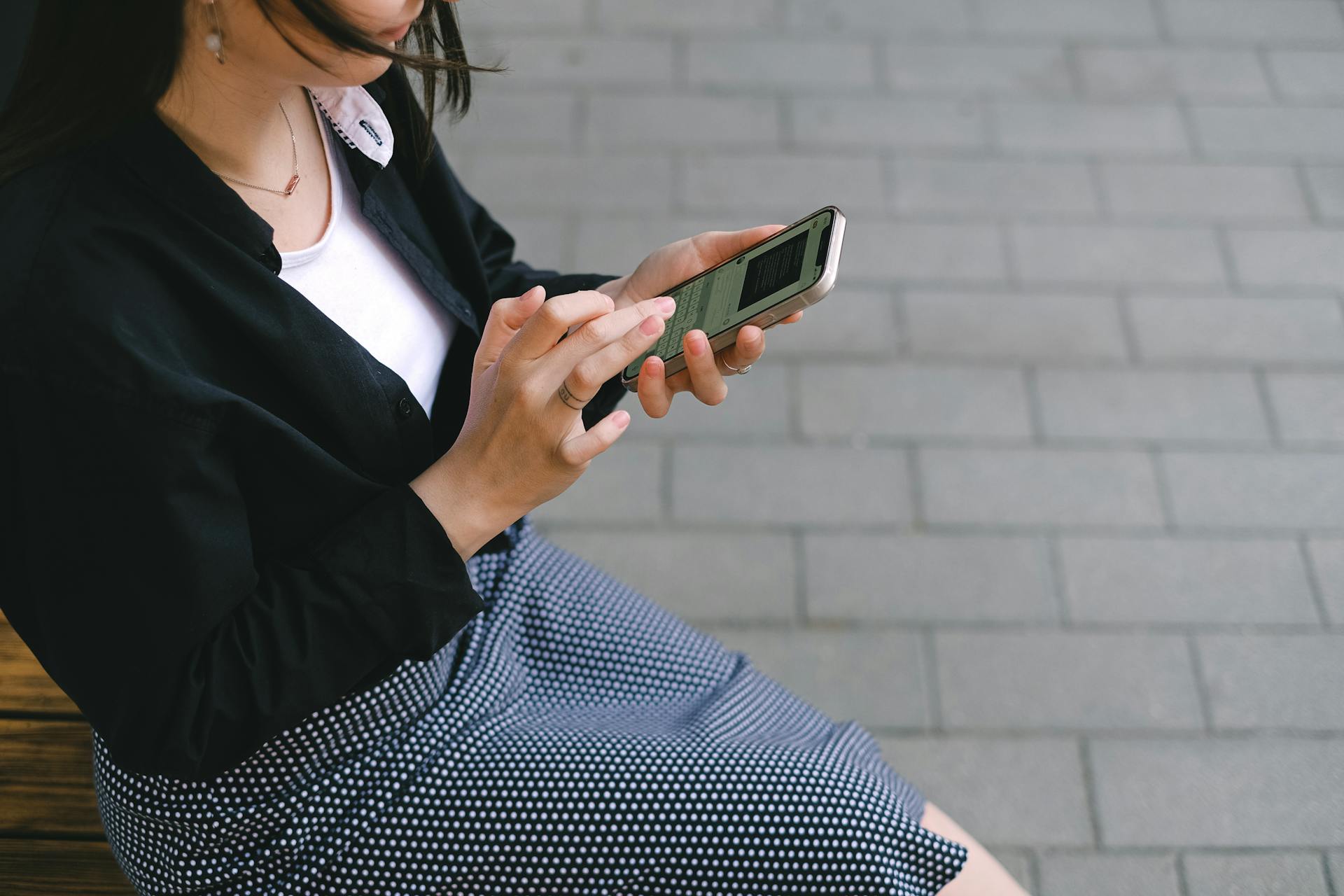 Woman using smartphone to interact with customer support chat, representing mobile-friendly ecommerce customer service and live chat automation.