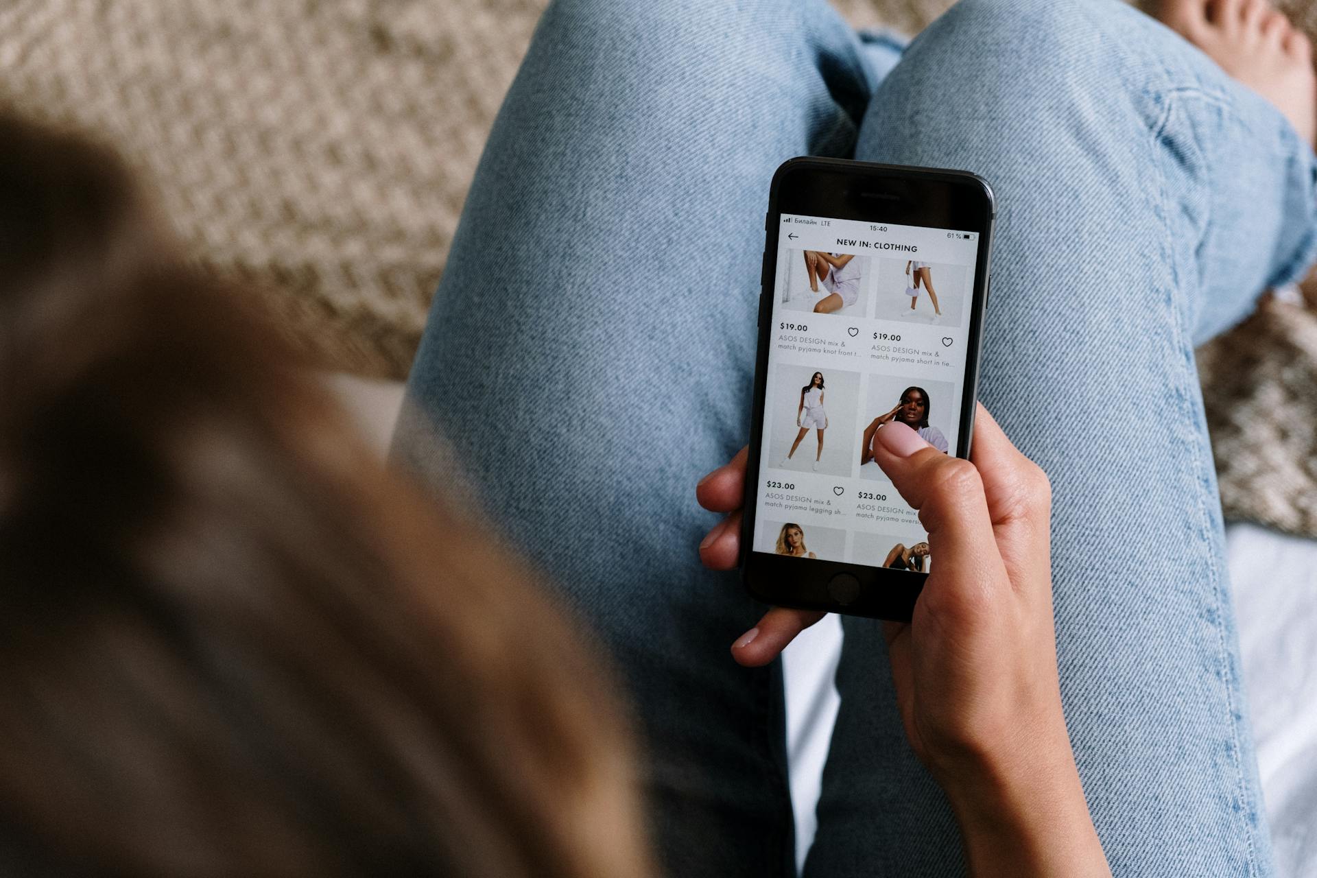 Person browsing an online clothing store on a mobile phone—highlighting the importance of mobile-optimized ecommerce experiences and CRO for smartphone users.