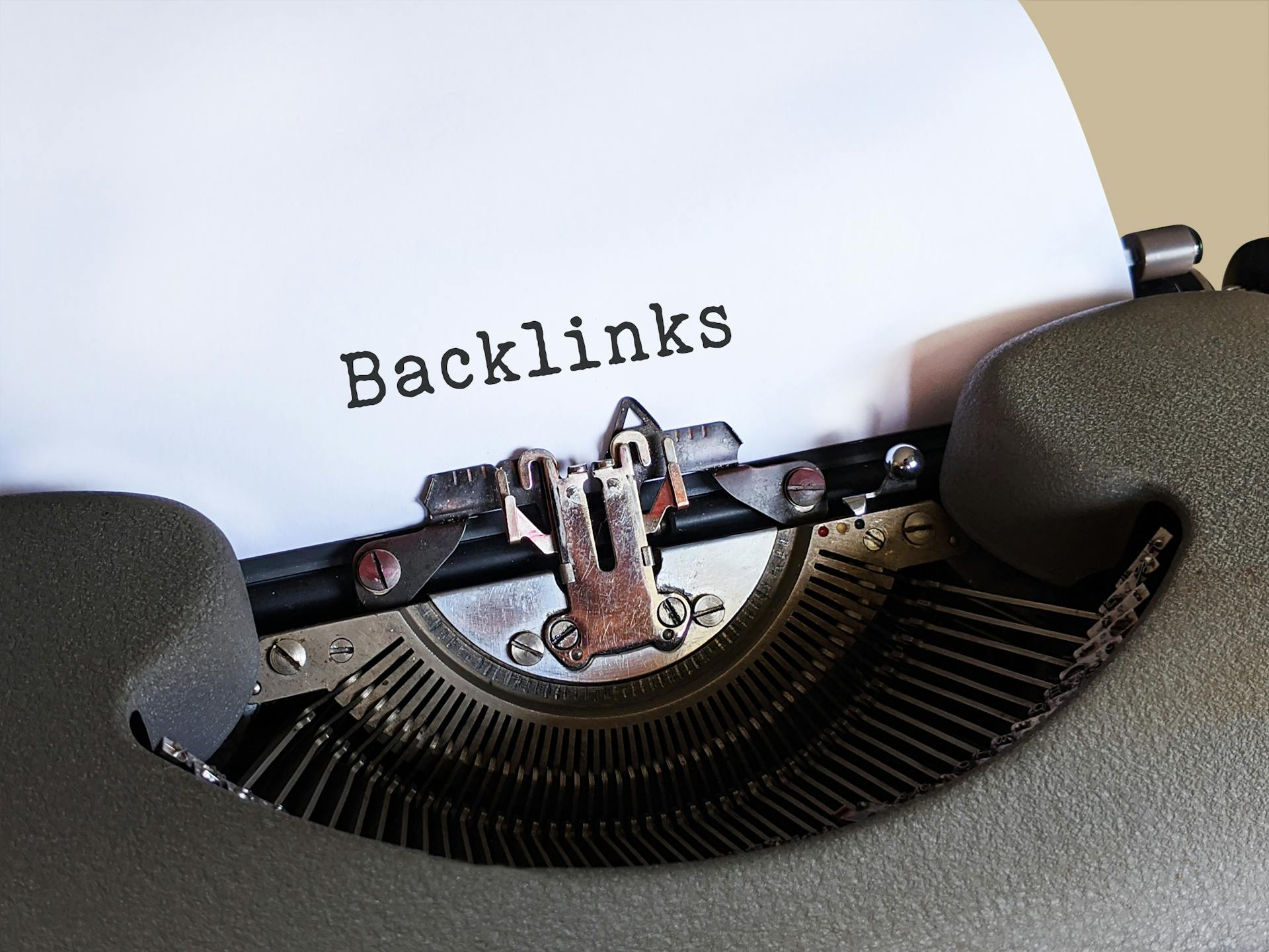 Close-up of a vintage typewriter with the word “Backlinks” typed on paper, symbolizing link-building strategies, off-page SEO, and improving search engine rankings through quality external links.