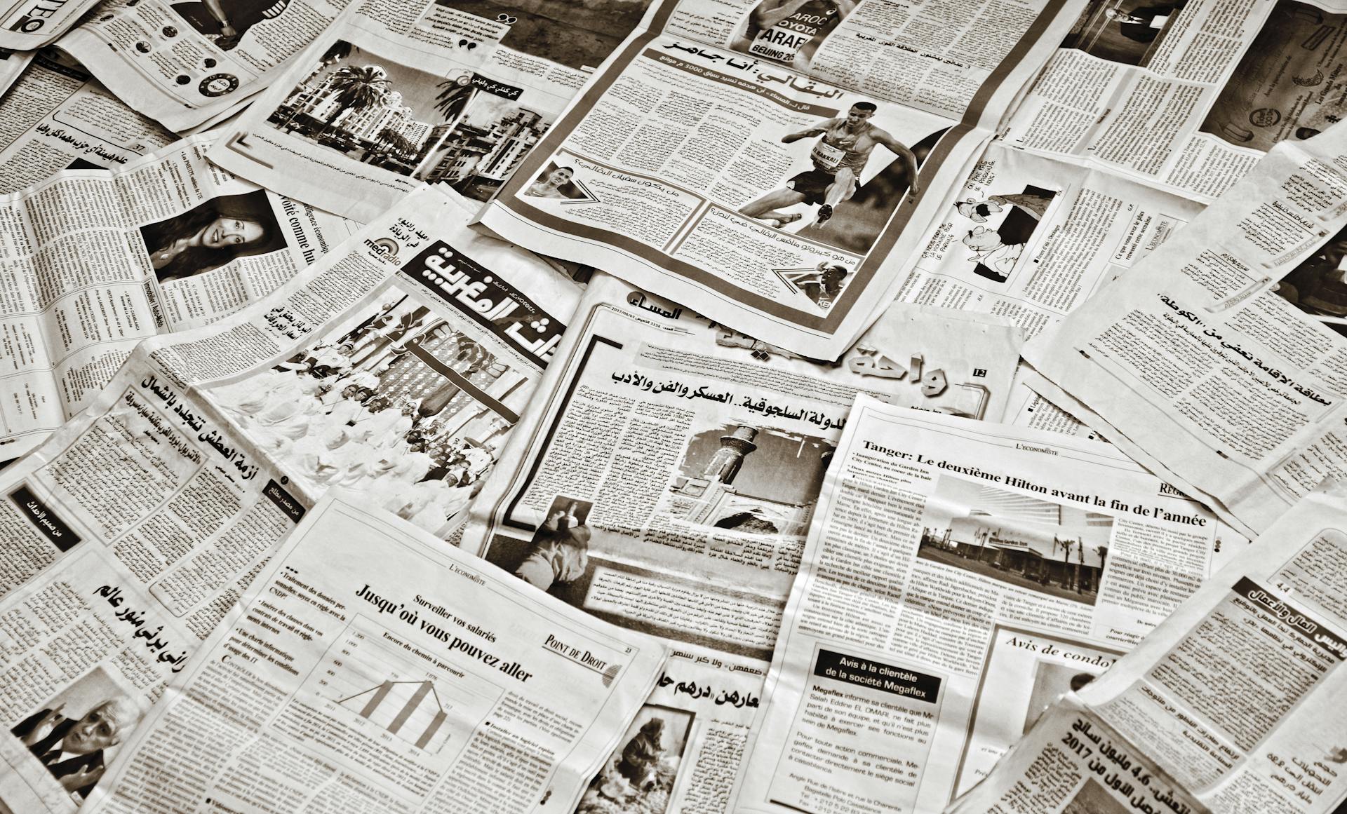 Scattered international newspapers in various languages, symbolizing multilingual content, global news distribution, and international SEO strategies for reaching diverse audiences.