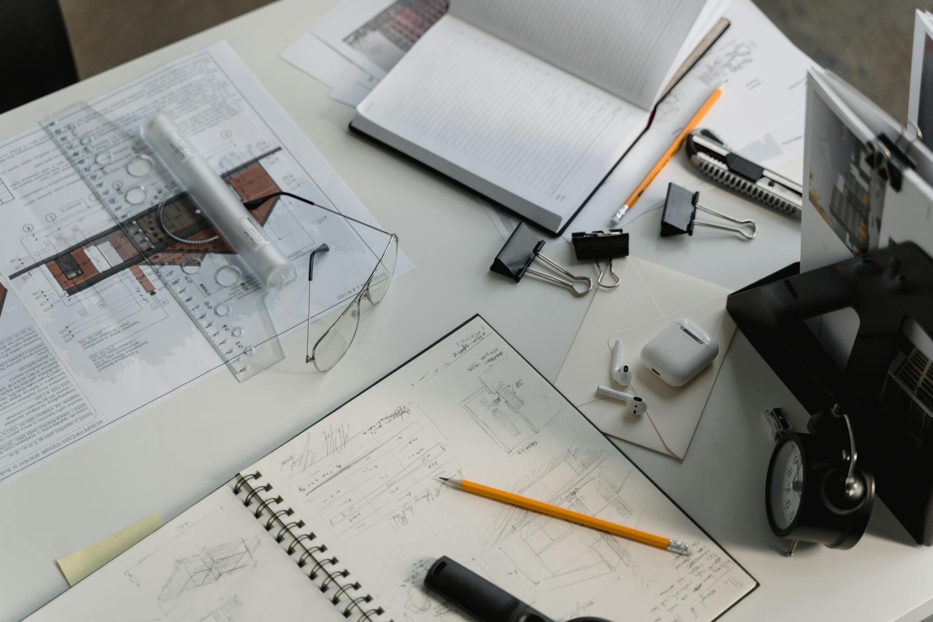 Architectural desk workspace with sketches, blueprints, tools, and notes, representing technical planning, global project development, and strategic execution for international business growth.
