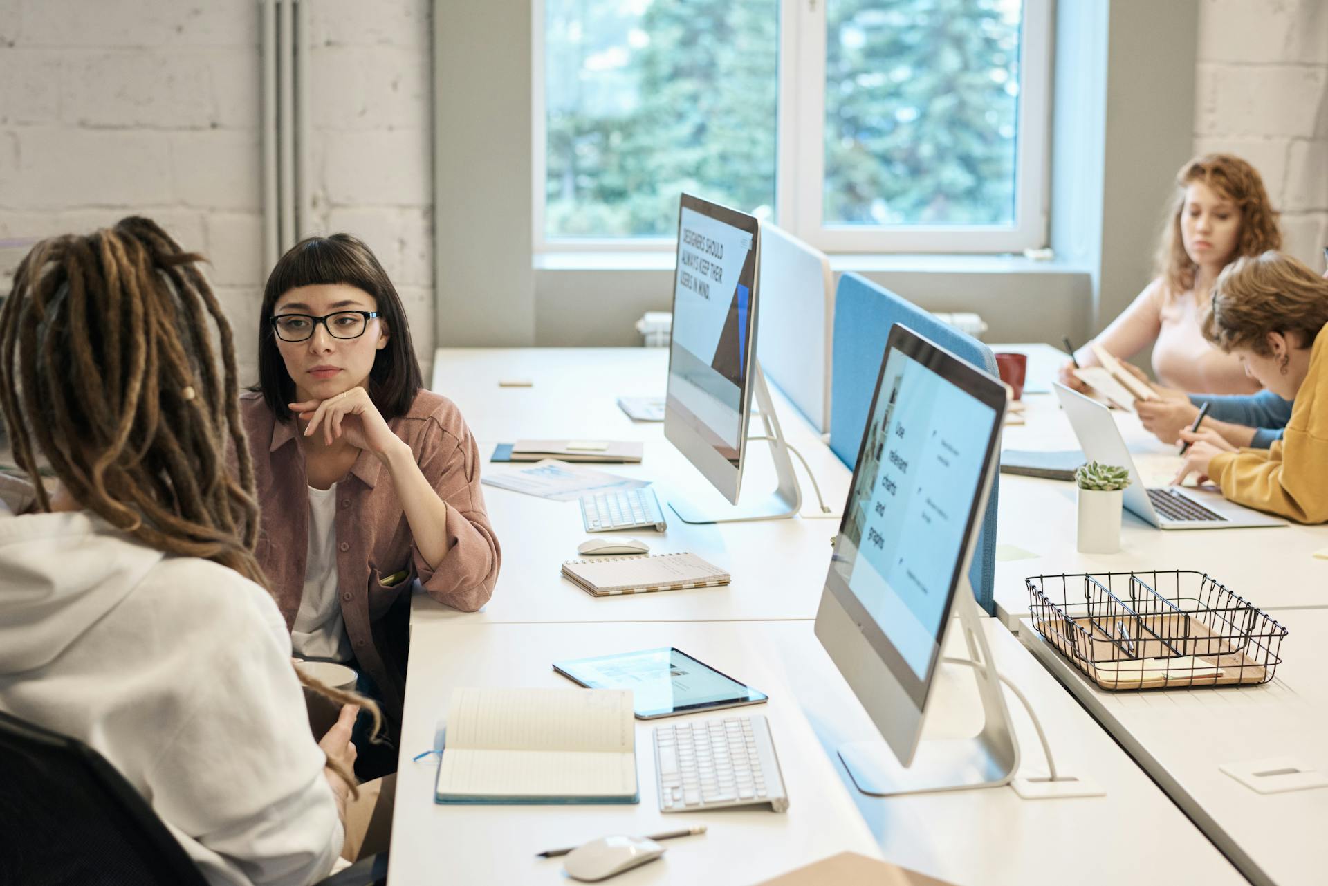 Team collaborating in a modern office with desktop computers, discussing digital strategy and website optimization for international SEO and global ecommerce growth.