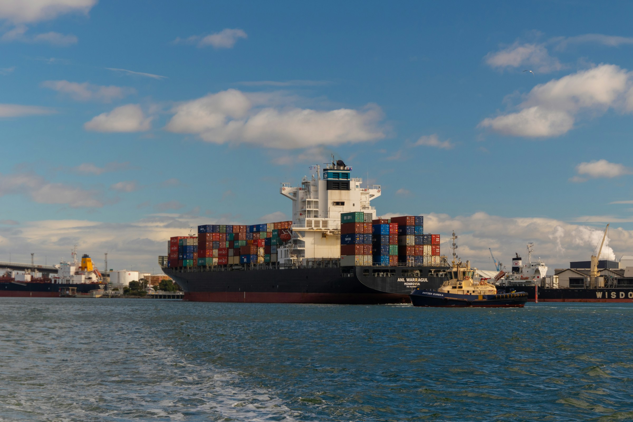 Large container ship loaded with colorful cargo containers docked at an international shipping port, illustrating global ecommerce logistics and freight transportation.